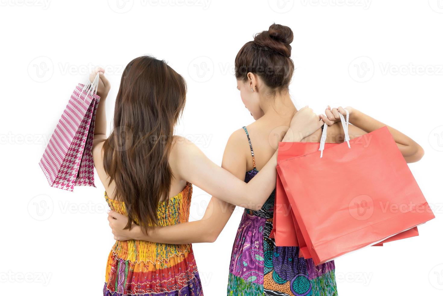due giovani donne che trasportano borse della spesa isolati su sfondo bianco foto