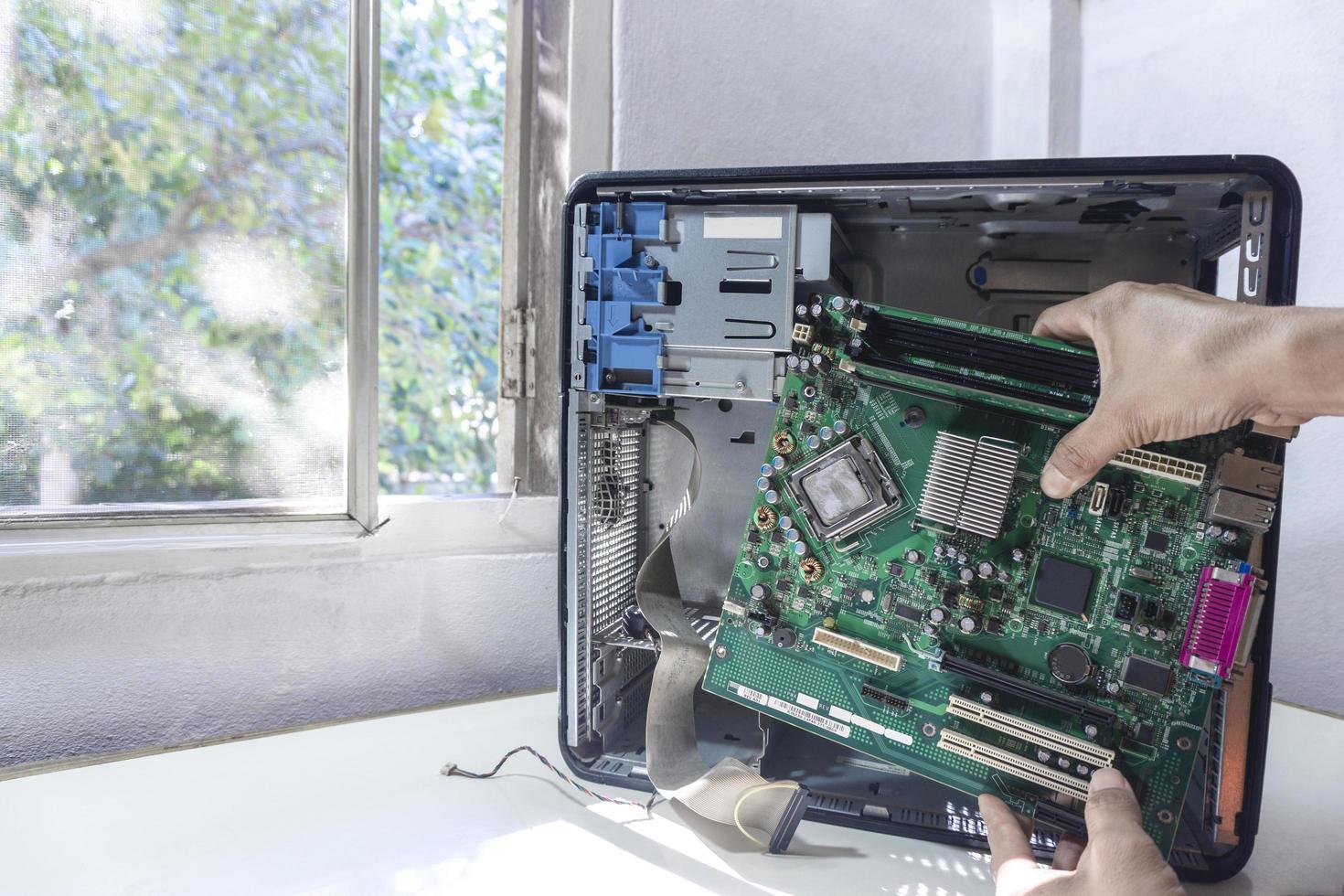 giovane tecnico riparatore che fissa o aggiorna la scheda madre su un computer foto