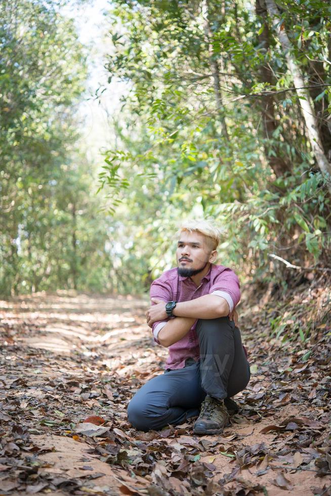 escursionista attivo giovane prendendo riposo con la natura dopo aver camminato attraverso la foresta foto