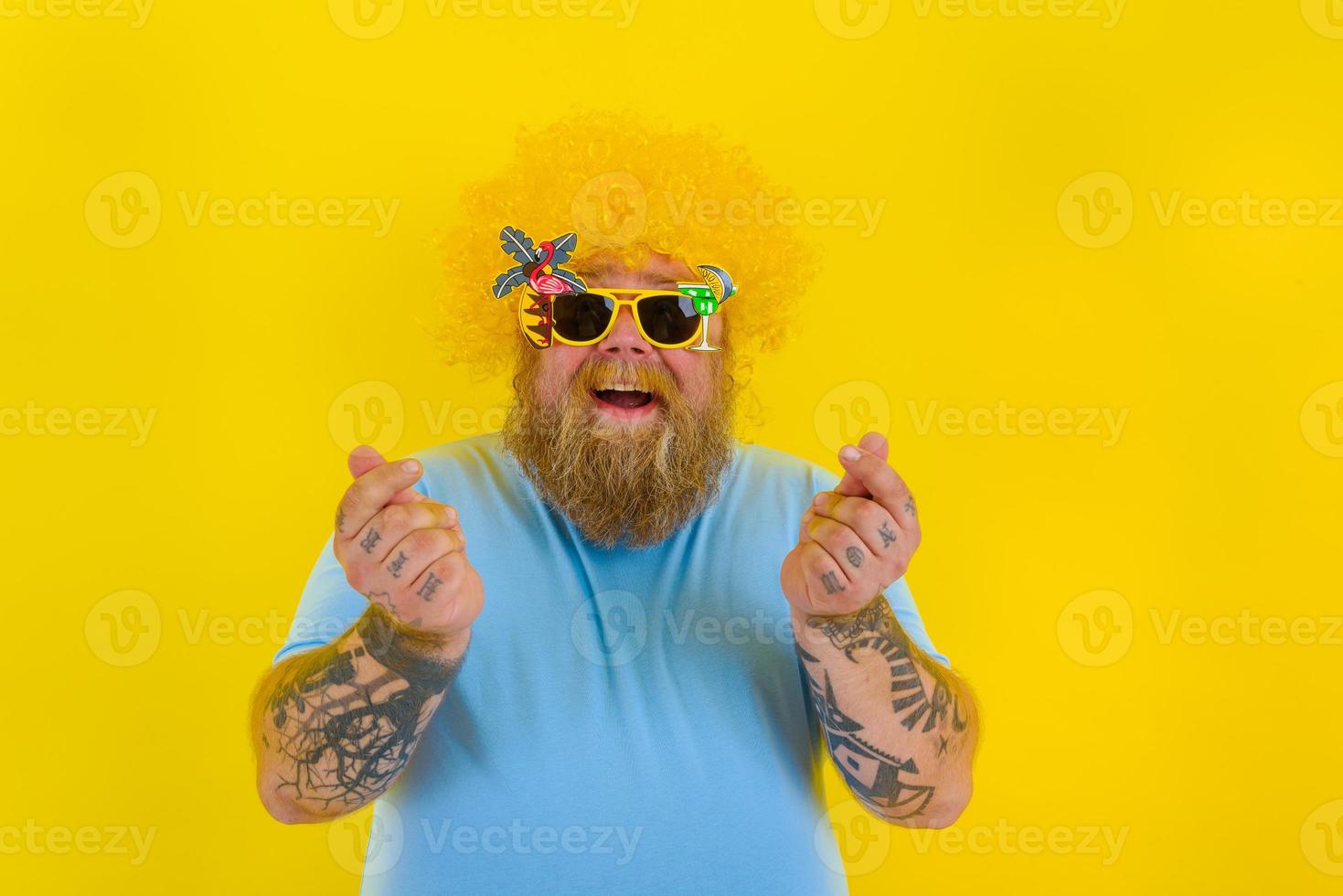 Grasso uomo con parrucca nel testa e occhiali da sole chiede per il i soldi foto