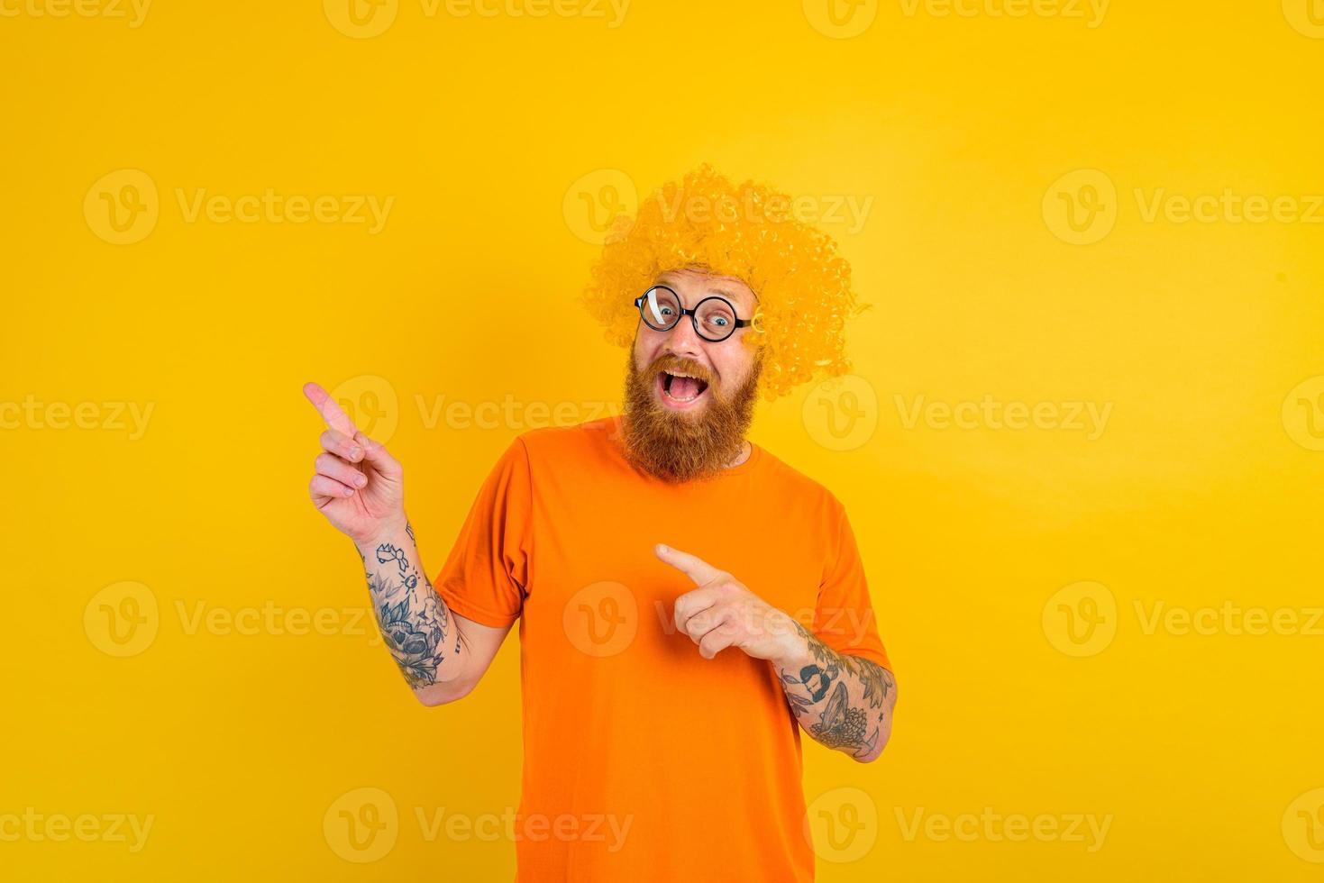 contento uomo con barba, giallo parrucca e bicchieri foto