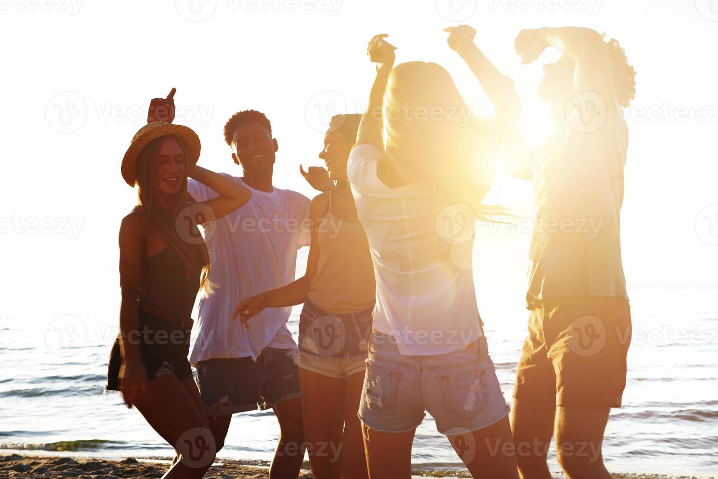 gruppo di amici danza su il spiaggia foto