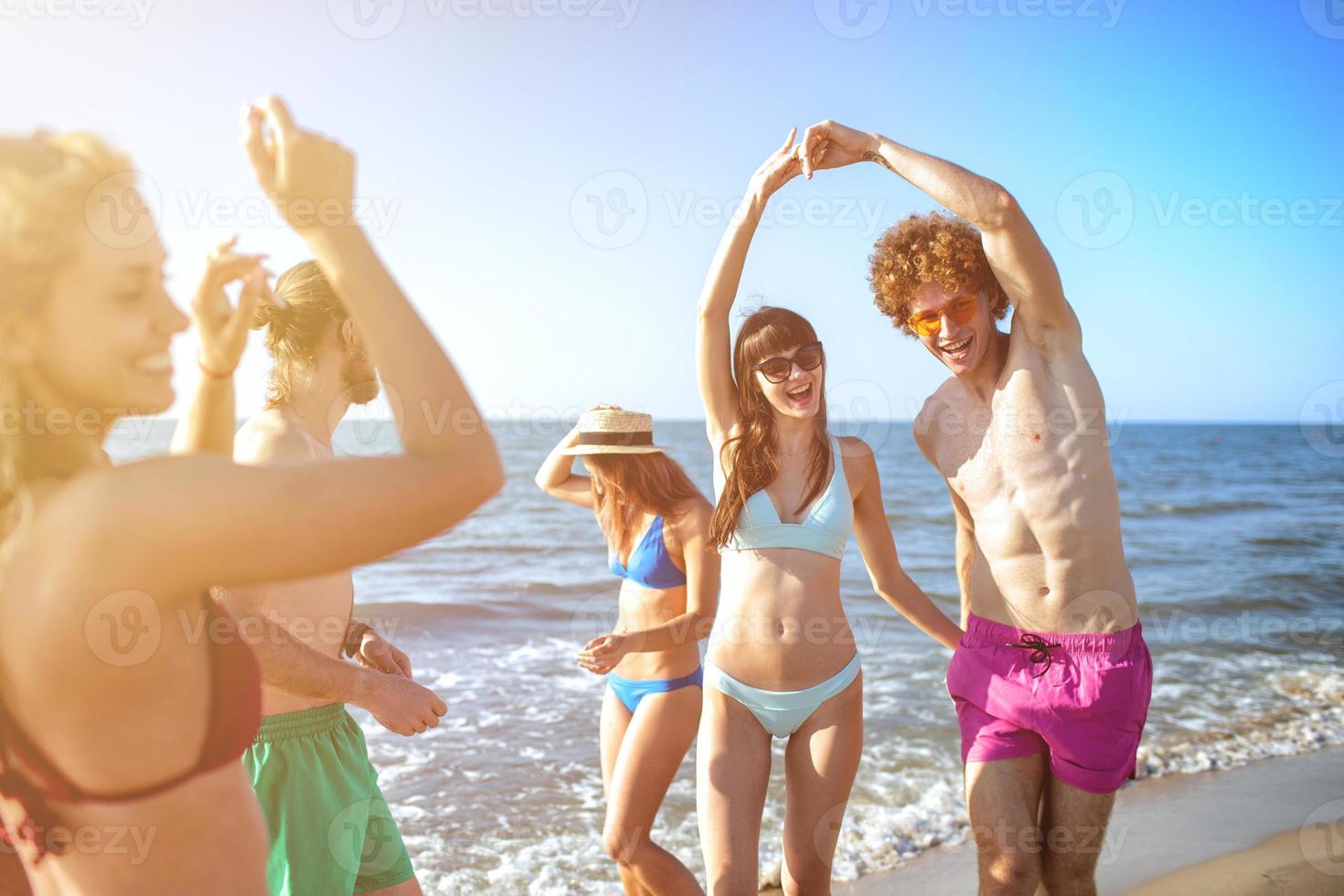 gruppo di amici danza su il spiaggia foto