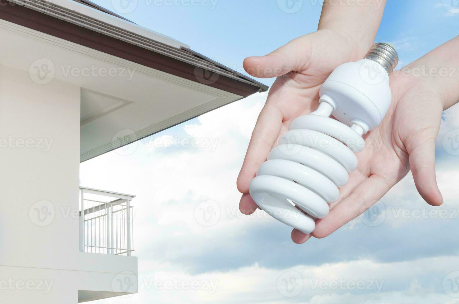 energia Salvataggio concetto, donna mano Tenere leggero lampadina su Casa sfondo, idee leggero lampadina nel il mano foto