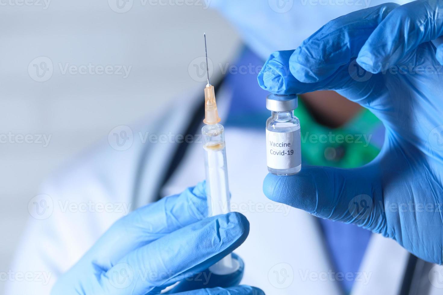 mano in guanti di lattice che tengono il vaccino contro il coronavirus foto