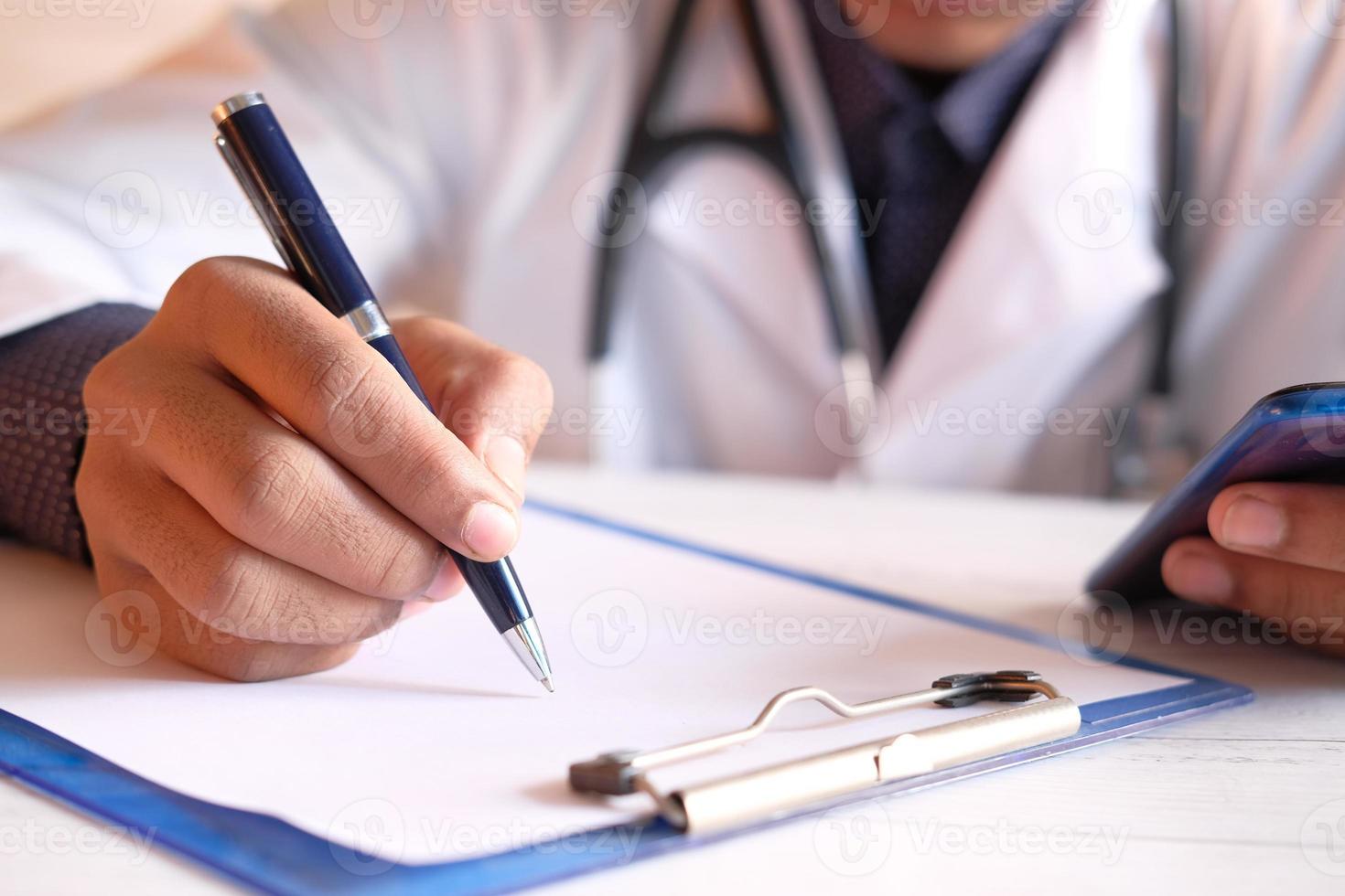 mani del medico che scrivono una prescrizione foto