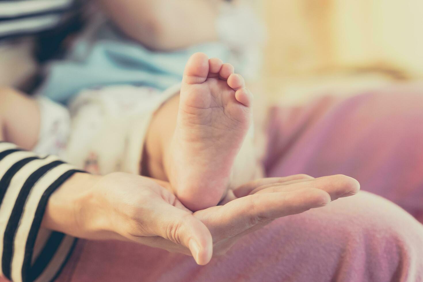 madre mano Tenere piedi bambino bambino con attento. foto