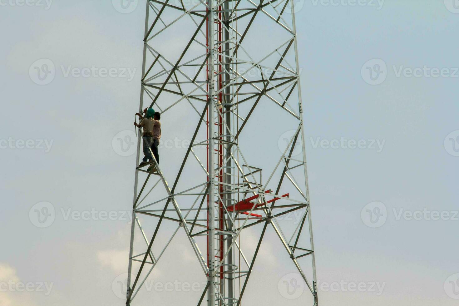 pittura cellula Telefono antenne e il Internet per migliorare bellezza di giovane corposo lavoratori con audacia per raggiungere altezza è un' pericoloso lavoro. foto