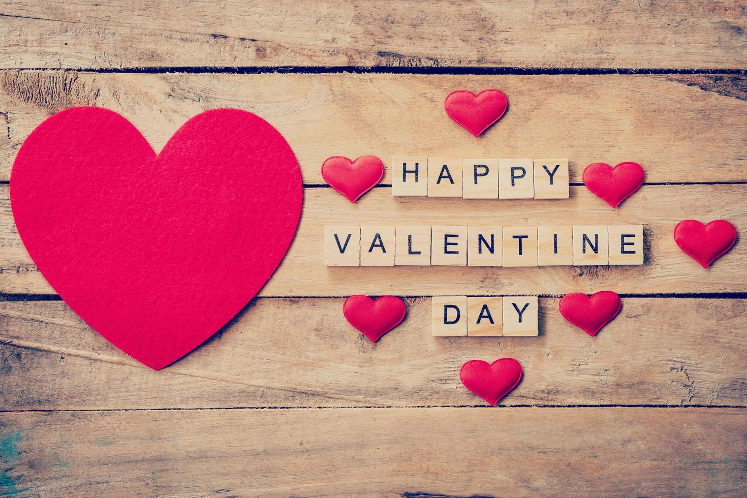 rosso cuore con di legno testo contento San Valentino giorno su legna tavolo sfondo. foto