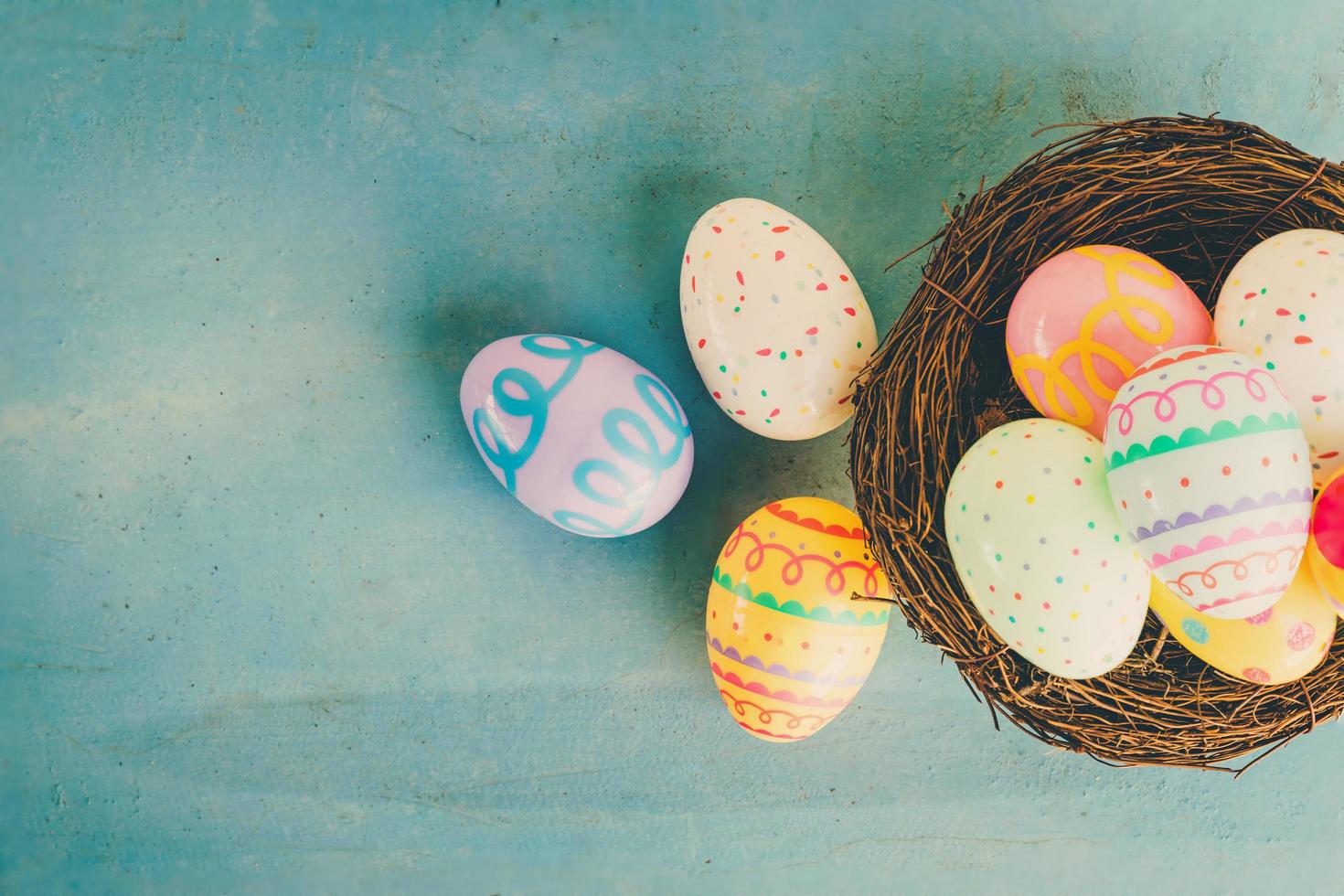 colorato Pasqua uova nel nido su blu legna sfondo con copia spazio. foto