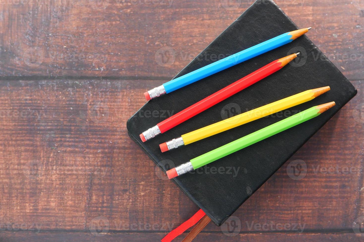Close up di matite colorate sul blocco note foto