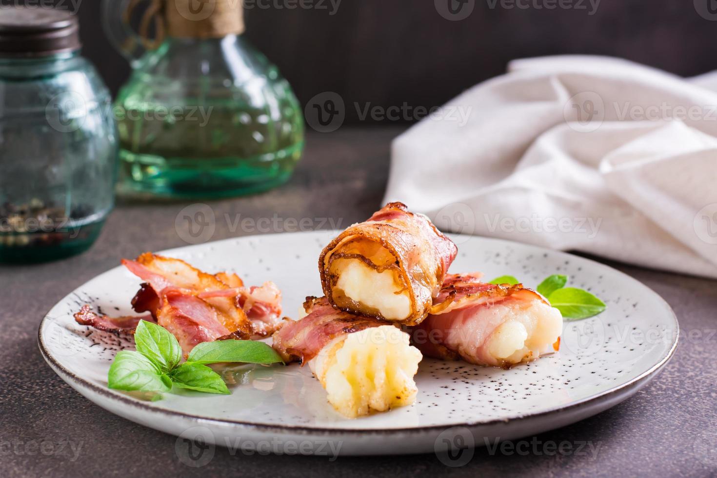 schiacciato patate avvolto nel fritte Bacon su un' piatto su il tavolo. foto