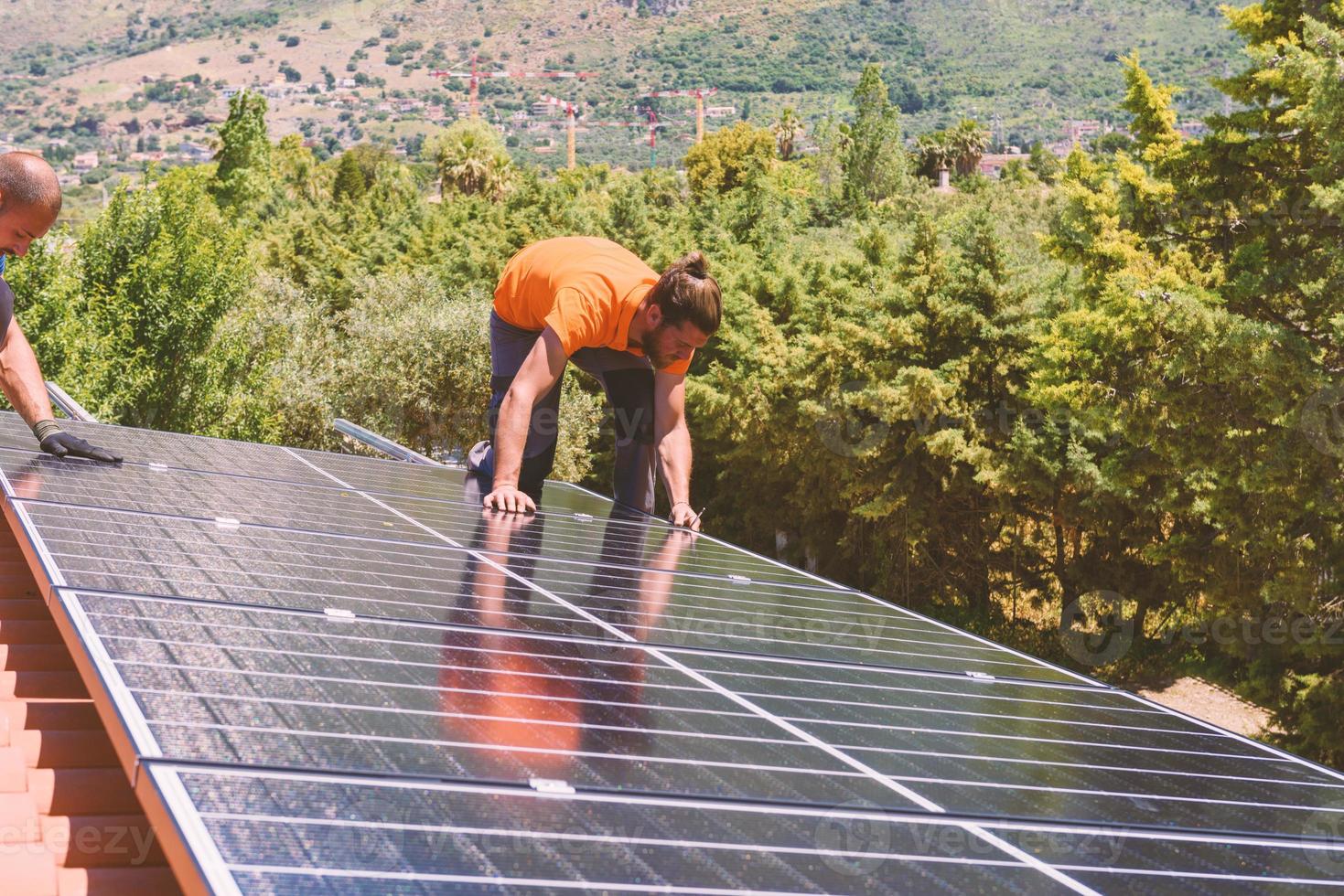 lavoratori montare energia sistema con solare pannello per elettricità foto