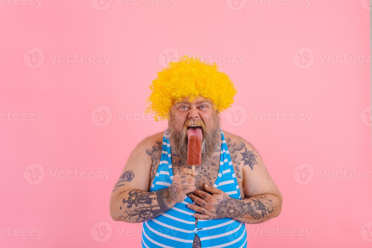 Grasso Affamato uomo con barba e parrucca mangia un' ghiacciolo foto