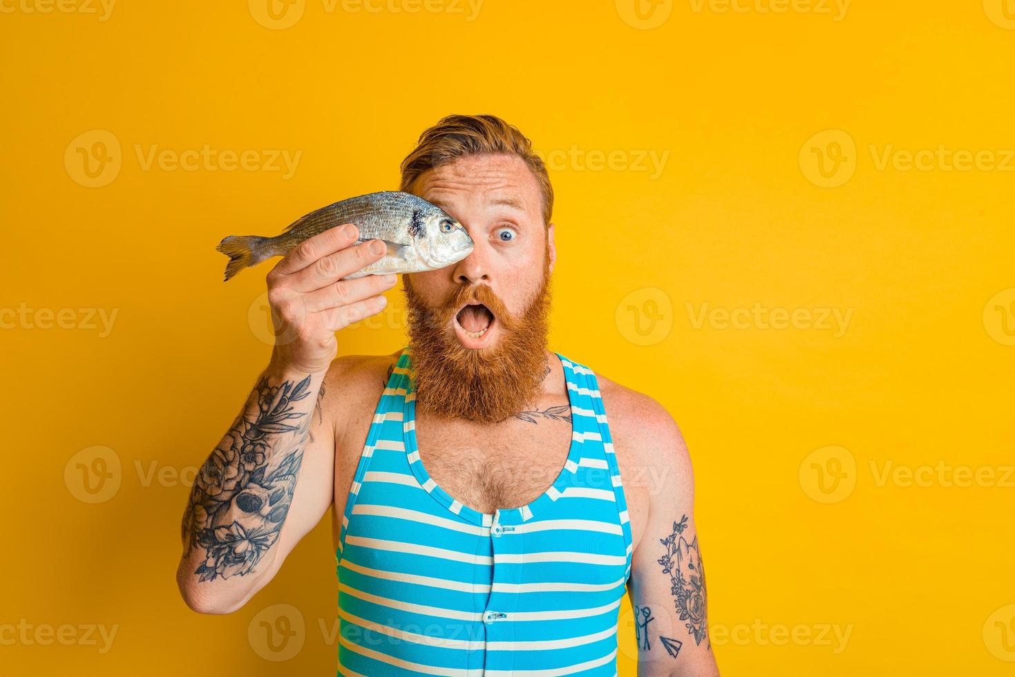 uomo con barba e costume da bagno catturato un' pesce foto