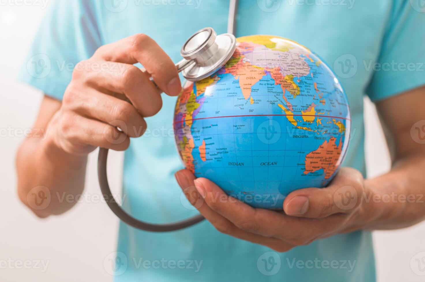 medico che tiene uno stetoscopio a un concetto di globo del mondo foto