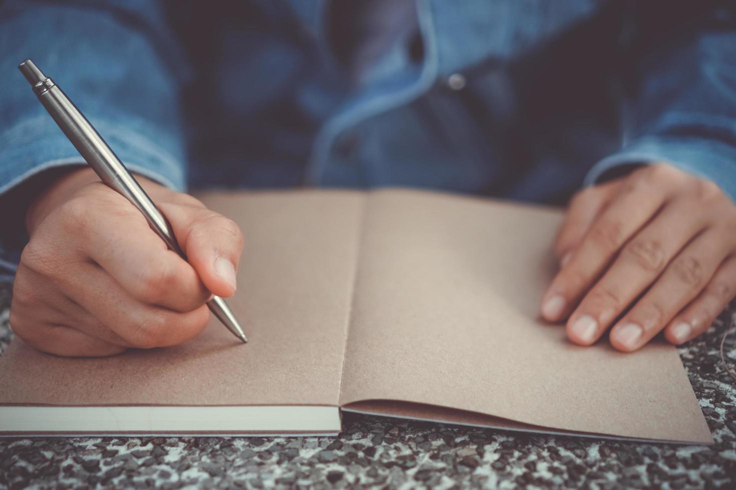 donna mano che scrive in un piccolo taccuino memo foto