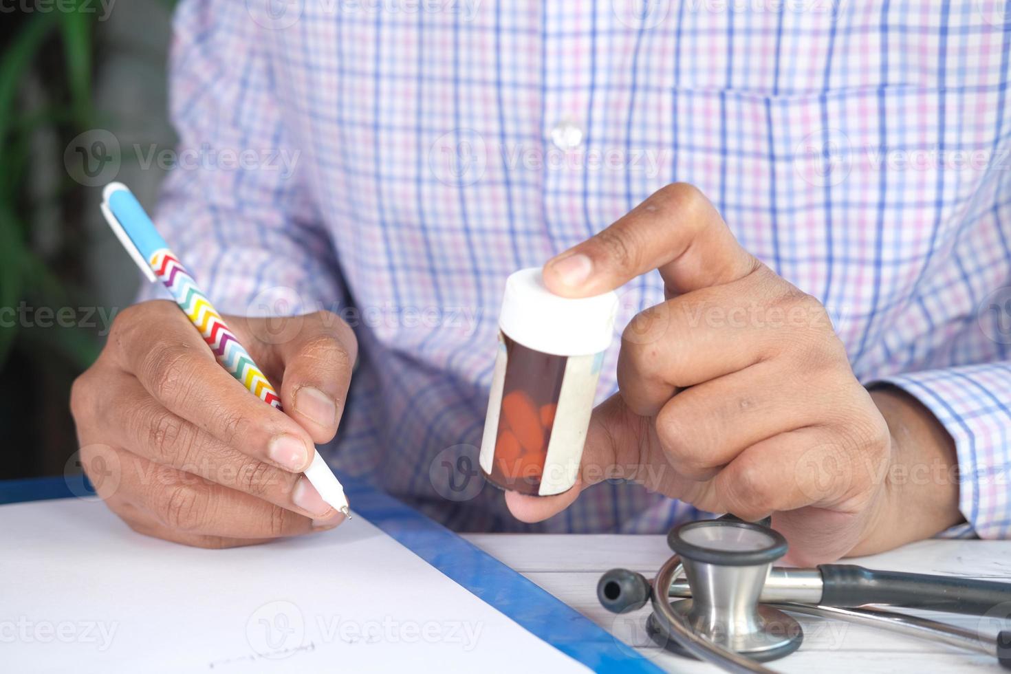 prescrizione di scrittura a mano del medico sulla scrivania foto