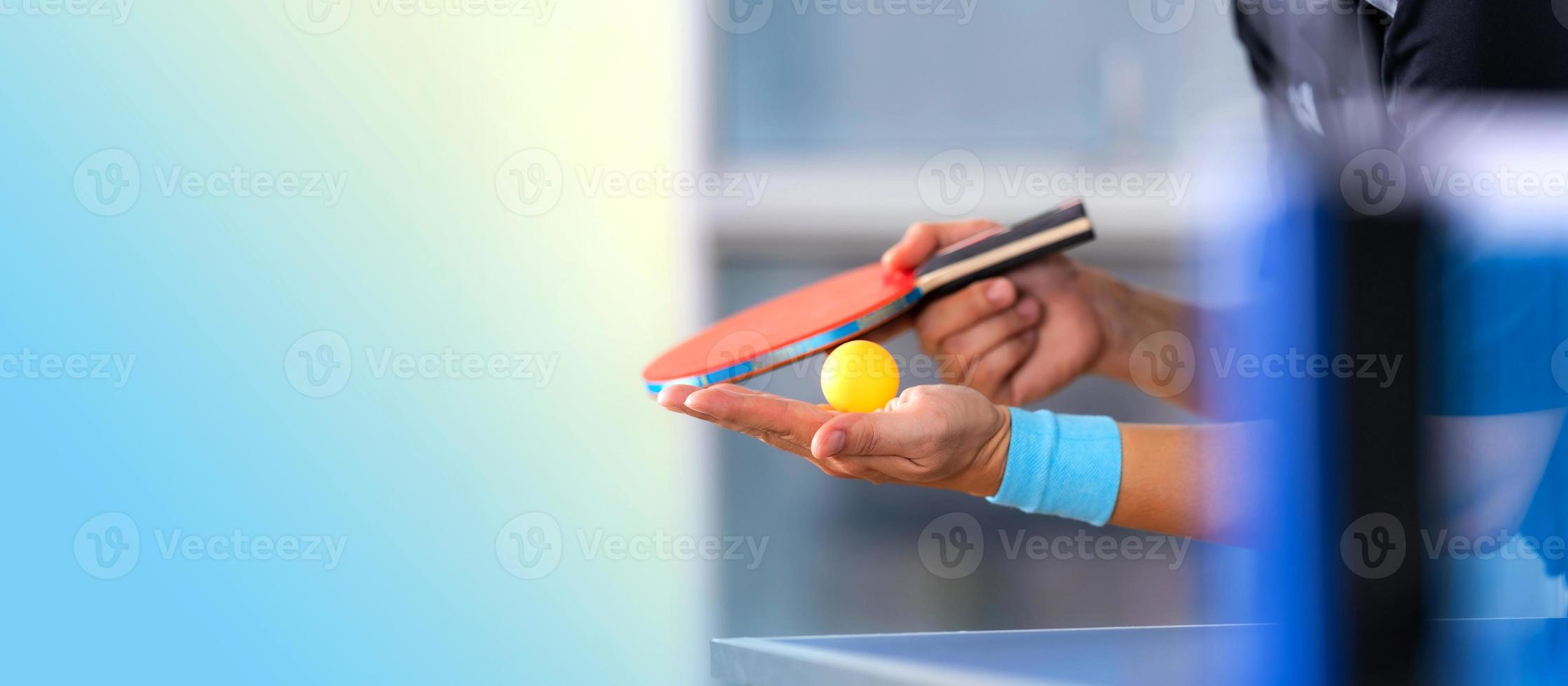 maschio giocando a ping pong con racchetta e palla in un palazzetto dello sport foto