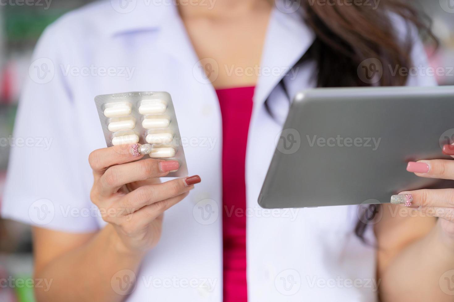 il farmacista tiene la scatola della medicina in farmacia foto