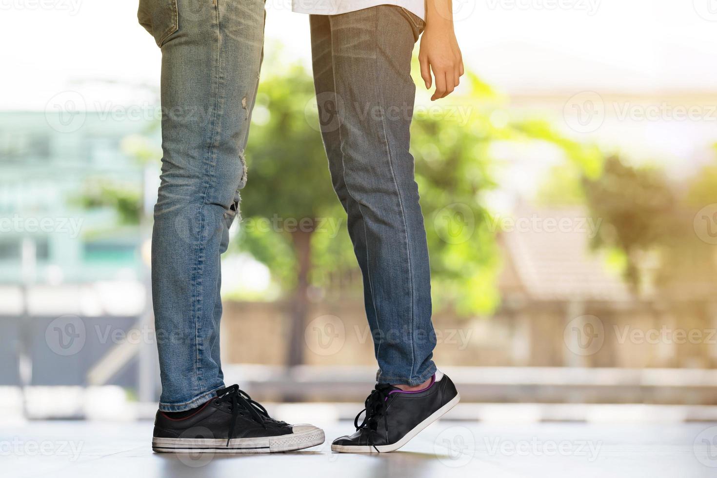 coppia che si bacia, ragazza si leva in piedi in punta di piedi per baciare il suo uomo foto