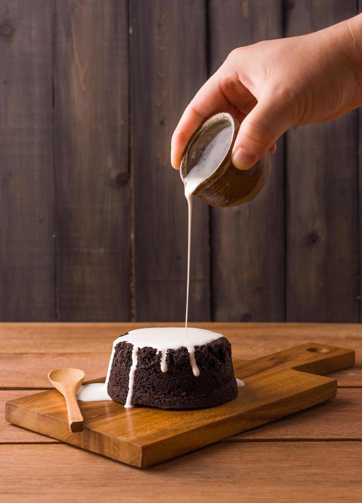 versando la glassa su una torta al cioccolato foto