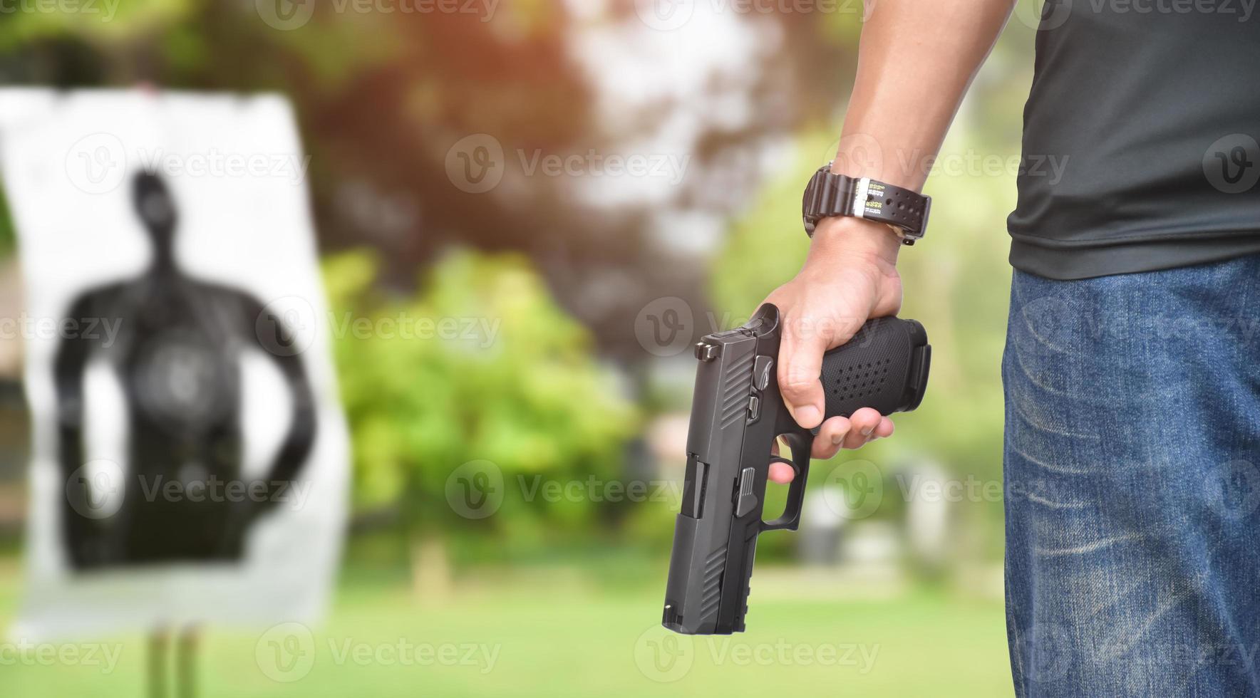 Pistola automatica da 9 mm che tiene nella mano destra del tiratore, concetto di sicurezza, rapina, gangster, guardia del corpo in tutto il mondo. messa a fuoco selettiva sulla pistola. foto