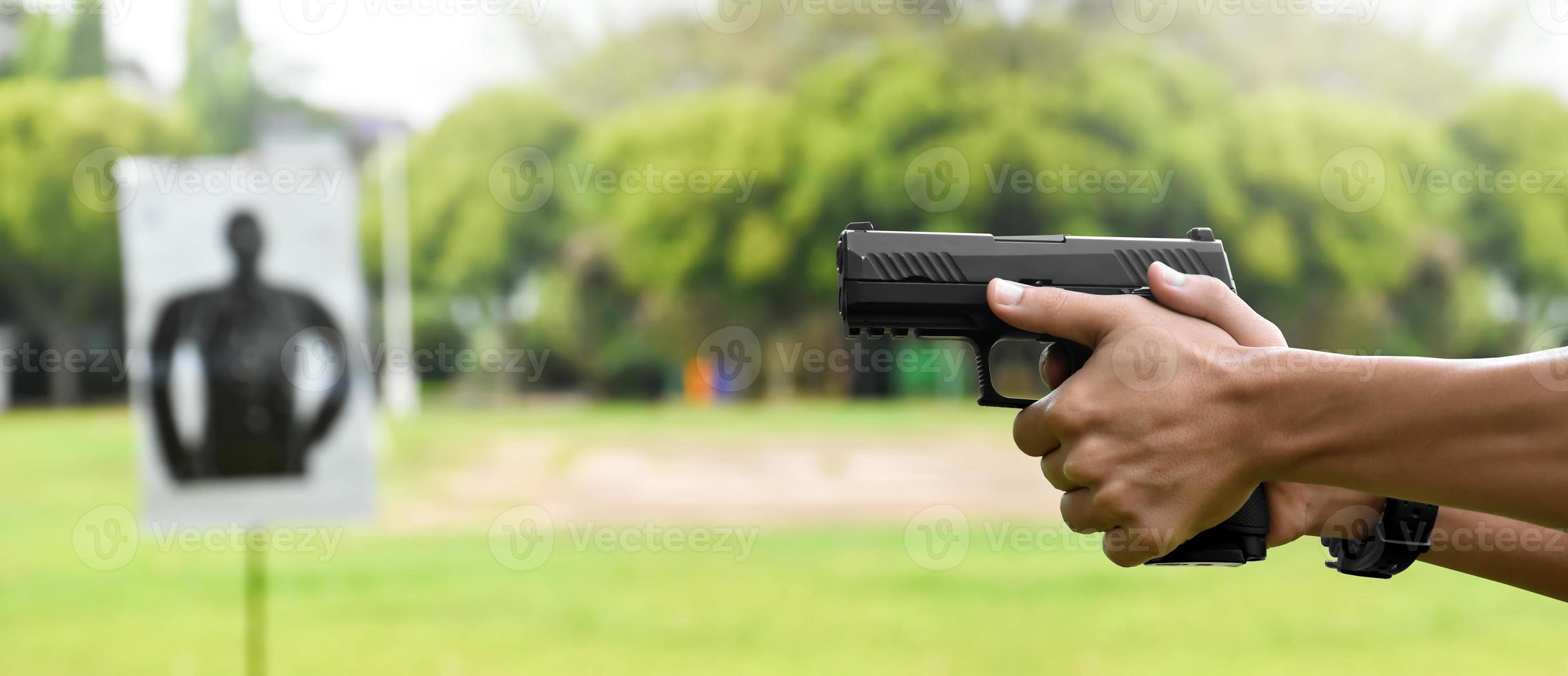 Pistola automatica da 9 mm che tiene nella mano destra del tiratore, concetto di sicurezza, rapina, gangster, guardia del corpo in tutto il mondo. messa a fuoco selettiva sulla pistola. foto