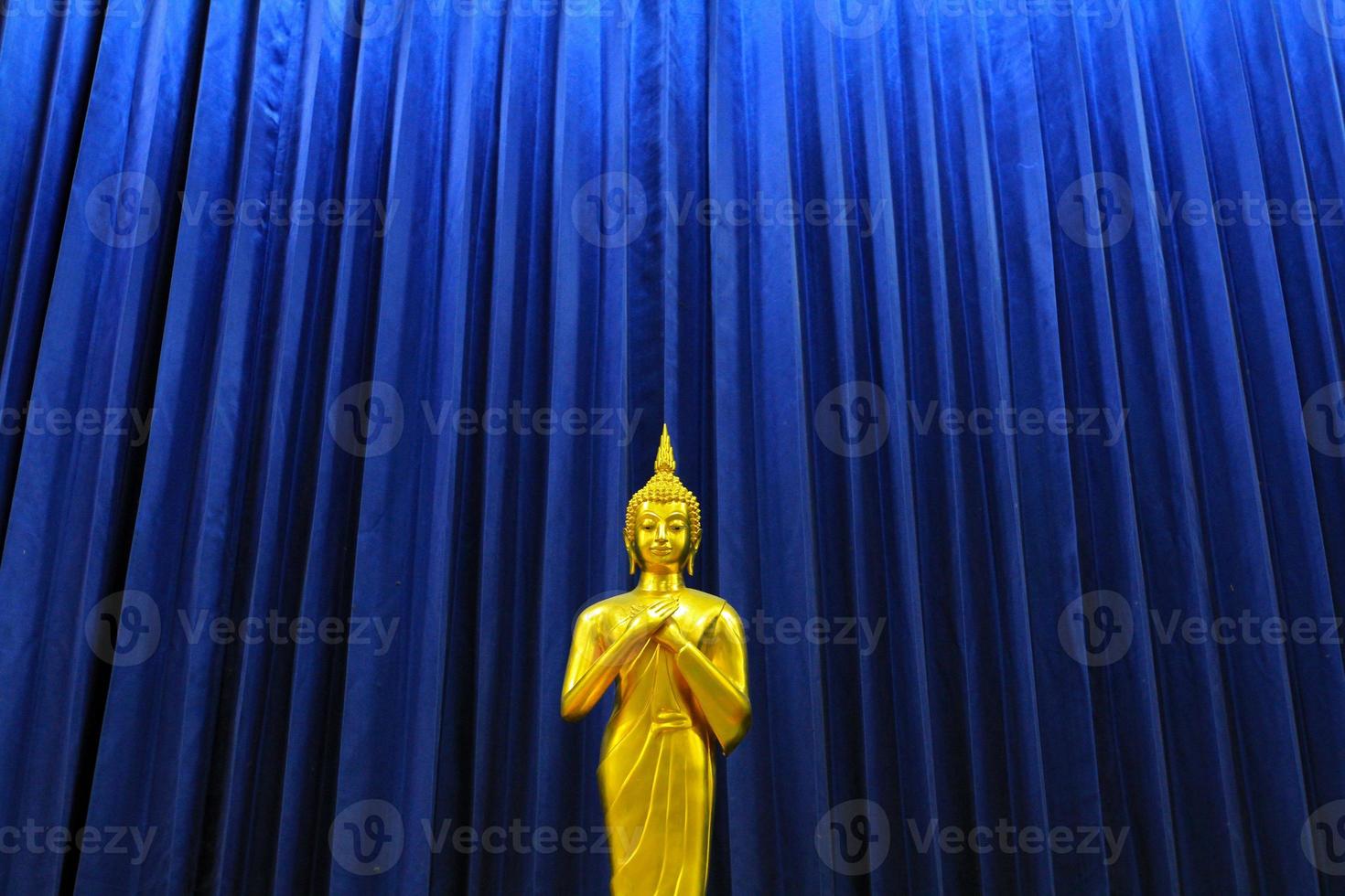 d'oro Budda statua su modello di blu tenda sfondo. religione, fede, buddista e antico, oro oggetto con copia spazio. foto