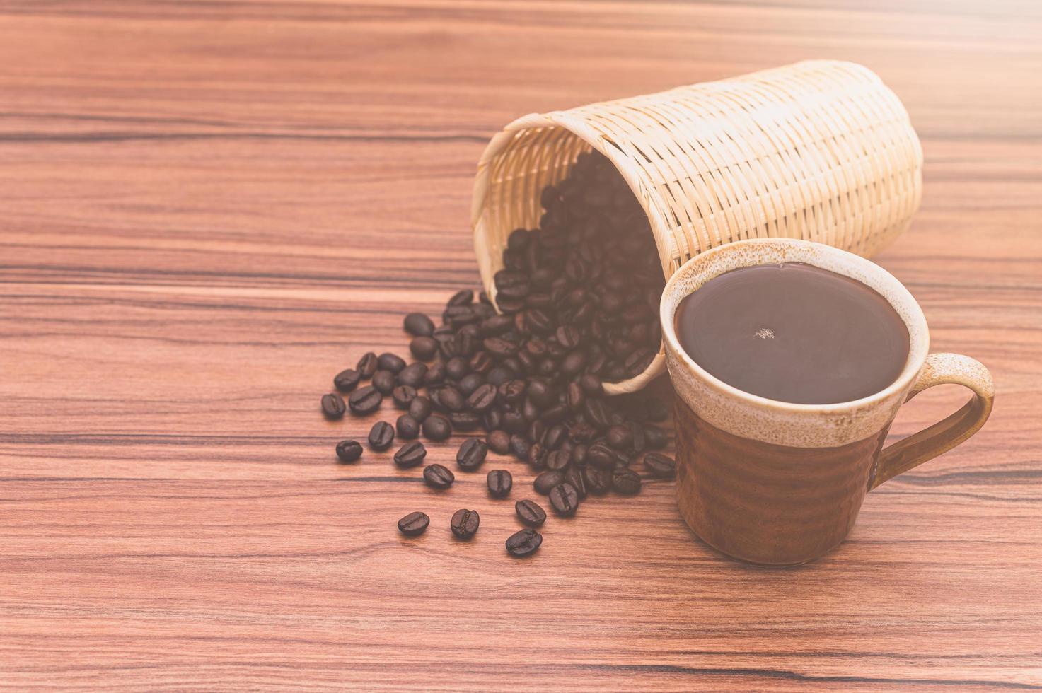 chicchi di caffè e tazza di caffè sul tavolo foto