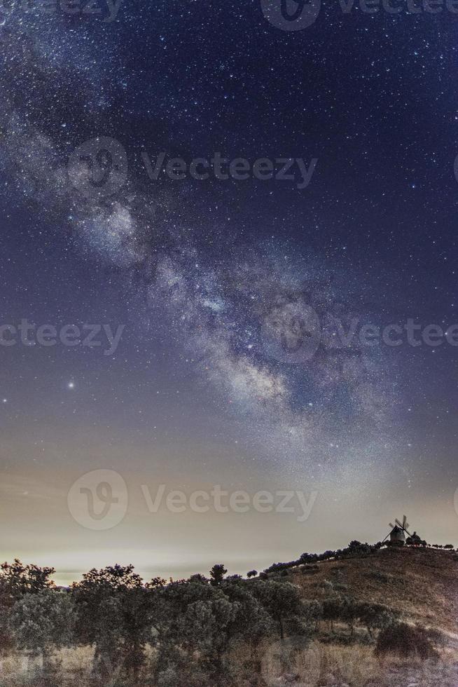 la via lattea con un mulino a vento sullo sfondo foto