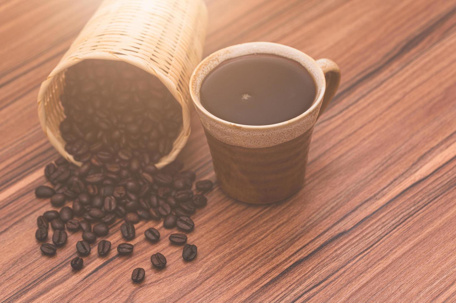 chicchi di caffè e tazza di caffè sul tavolo foto