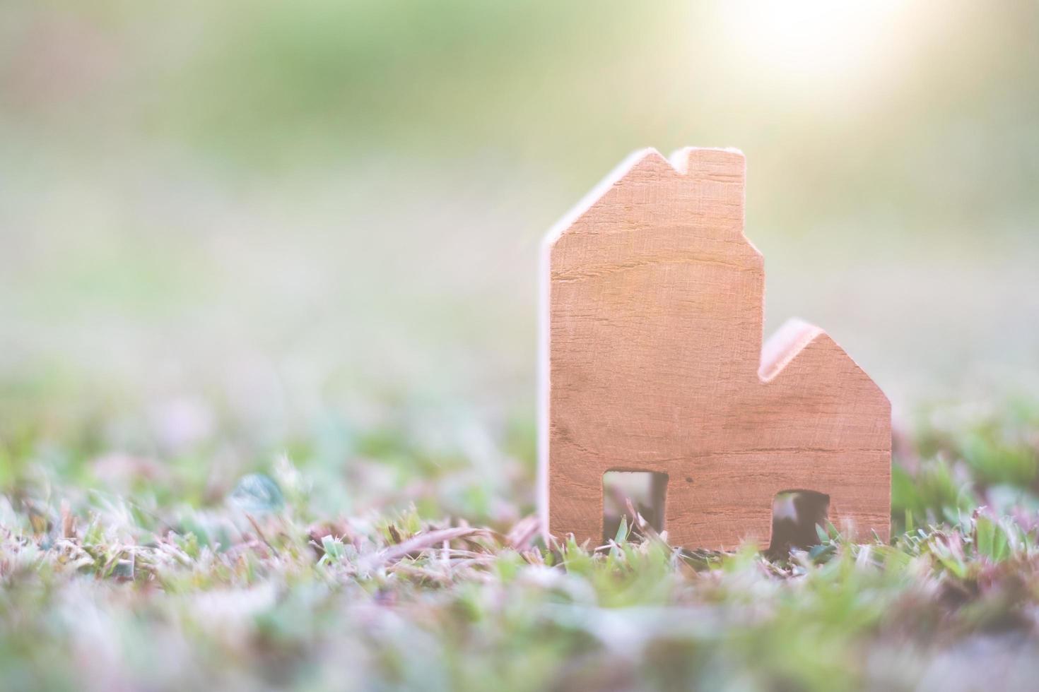 modello di casa in legno sul concetto di terreno, alloggio e immobiliare foto