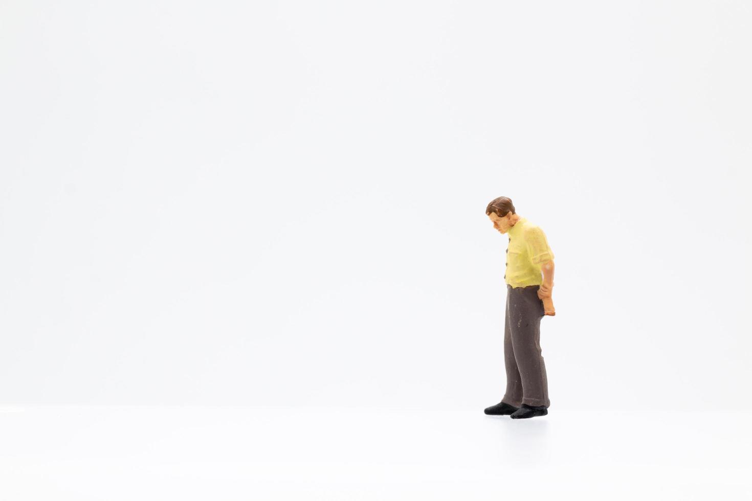 una persona in miniatura in piedi su uno sfondo bianco foto
