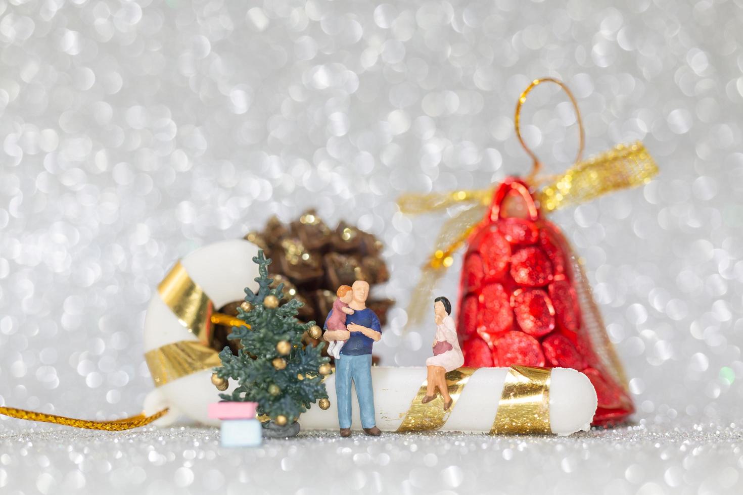 famiglia felice in miniatura che celebra il concetto di natale, natale e felice anno nuovo foto