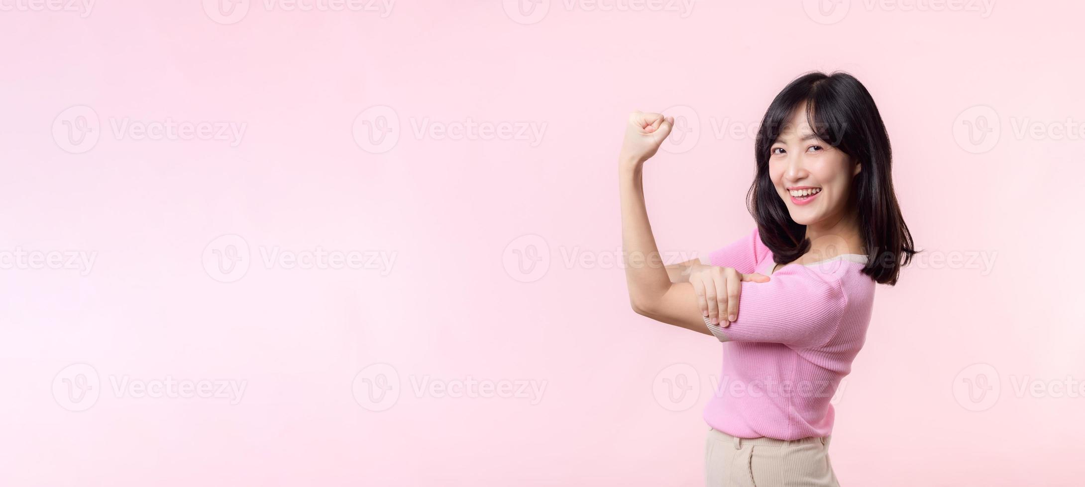 ritratto giovane asiatico donna orgoglioso e fiducioso mostrando forte muscolo forza braccia flesso in posa, si sente di sua successo risultato. donne Potenziamento, uguaglianza, salutare forza e coraggio concetto foto