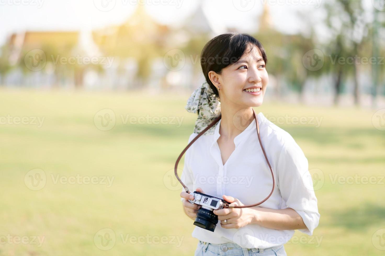 ritratto di asiatico donna viaggiatore utilizzando telecamera. Asia estate turismo vacanza concetto con il mille dollari palazzo nel un' sfondo a bangkok, Tailandia foto