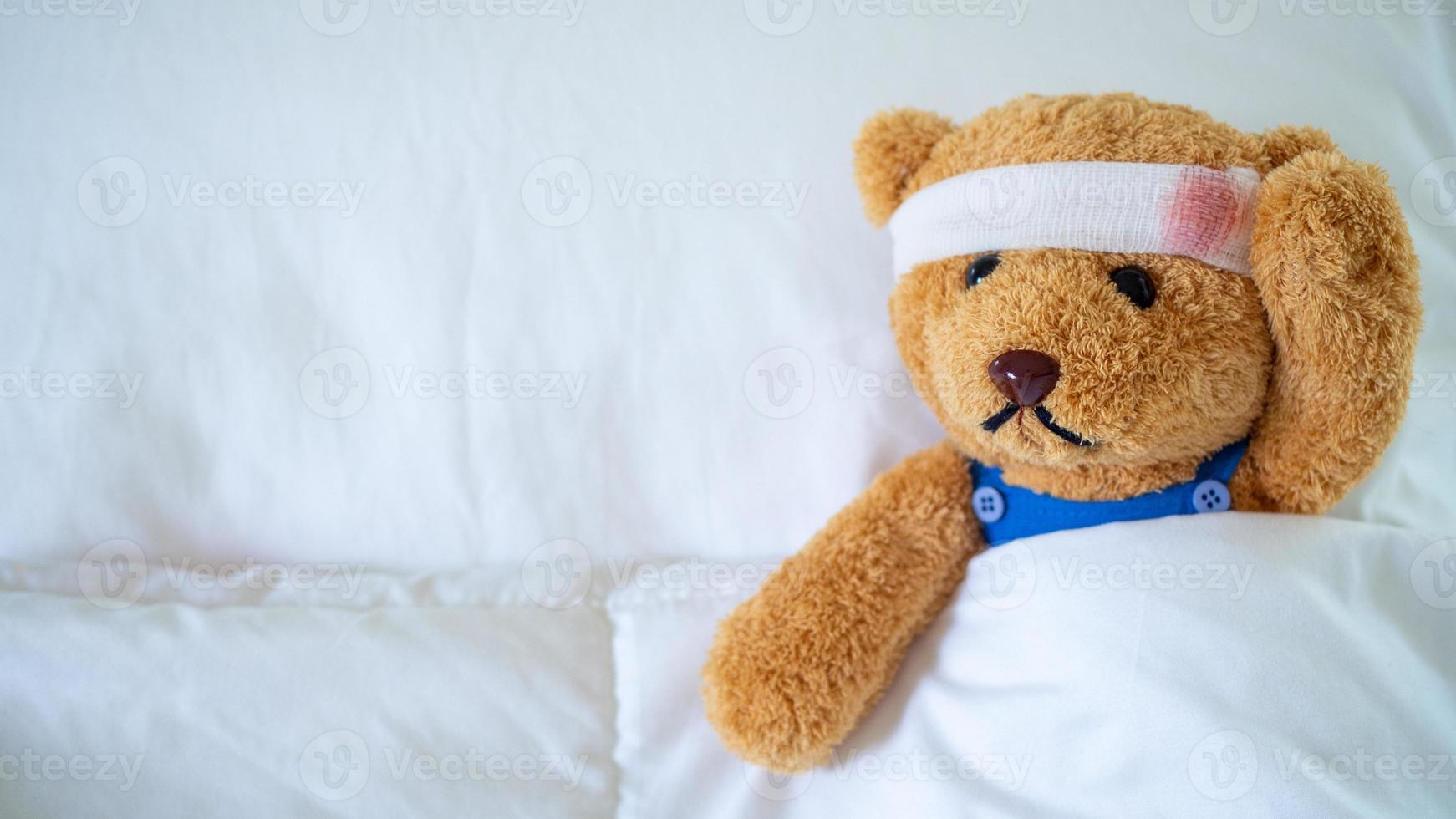 il orsacchiotto orso era malato nel letto dopo essere ferito nel un incidente. ottenere vita assicurazione e incidente assicurazione concetto foto