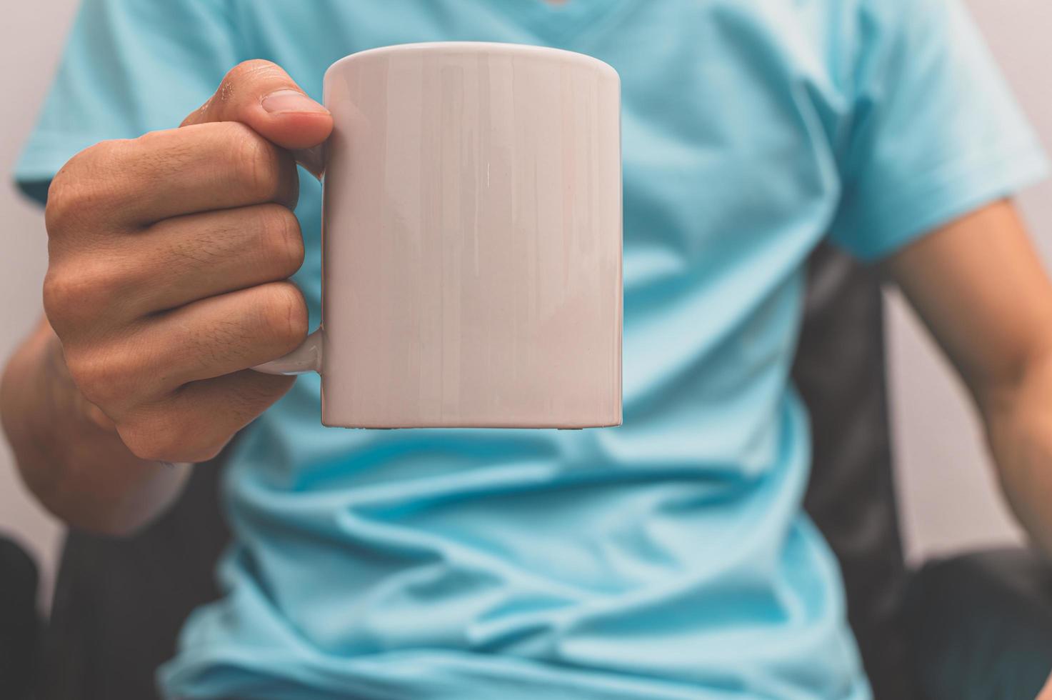 un uomo che tiene una tazza di caffè foto