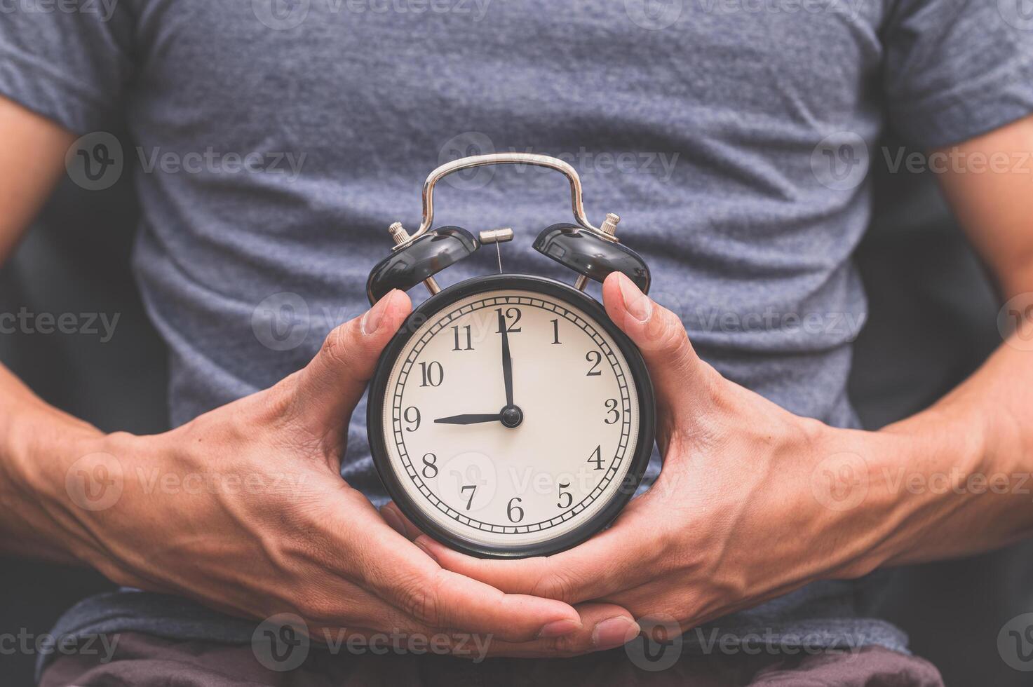 un uomo che tiene un orologio foto