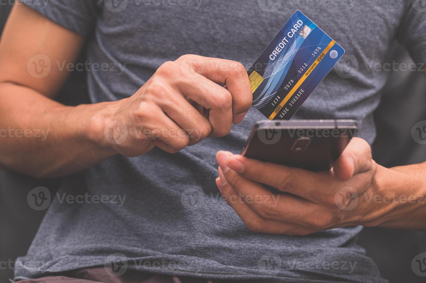 un uomo che utilizza una carta di credito con lo smartphone foto