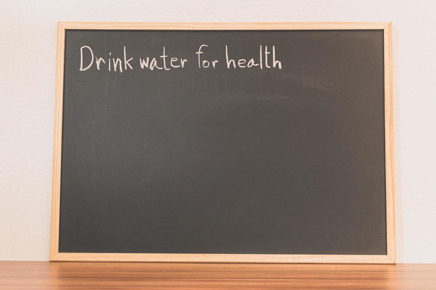 bere acqua per messaggio di salute sulla lavagna foto
