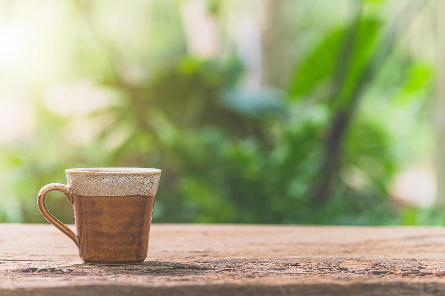 tazza di caffè sul tavolo con la luce solare foto