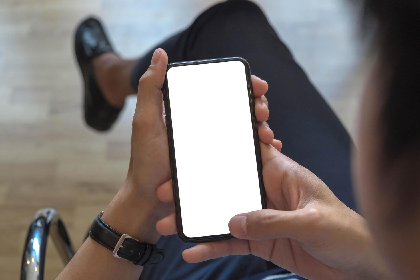 vista ritagliata del colpo delle mani dell'uomo che tengono il modello dello smartphone foto