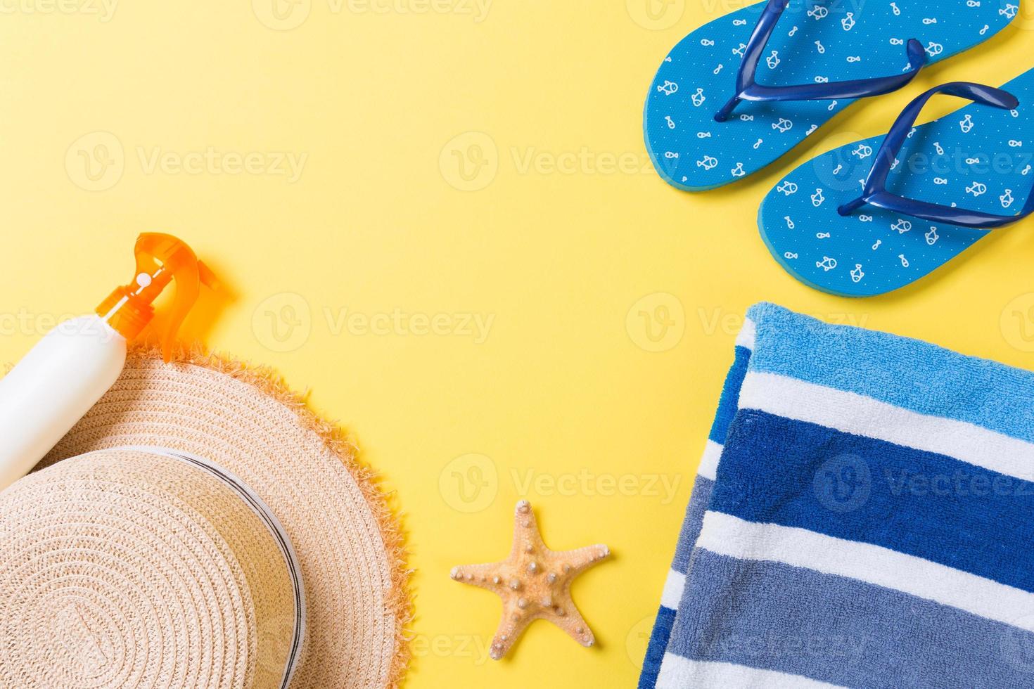 Flip flop, cannuccia cappello, stella marina, protezione solare bottiglia, corpo lozione spray su giallo sfondo superiore Visualizza . piatto posare estate spiaggia mare Accessori sfondo, vacanza concetto foto