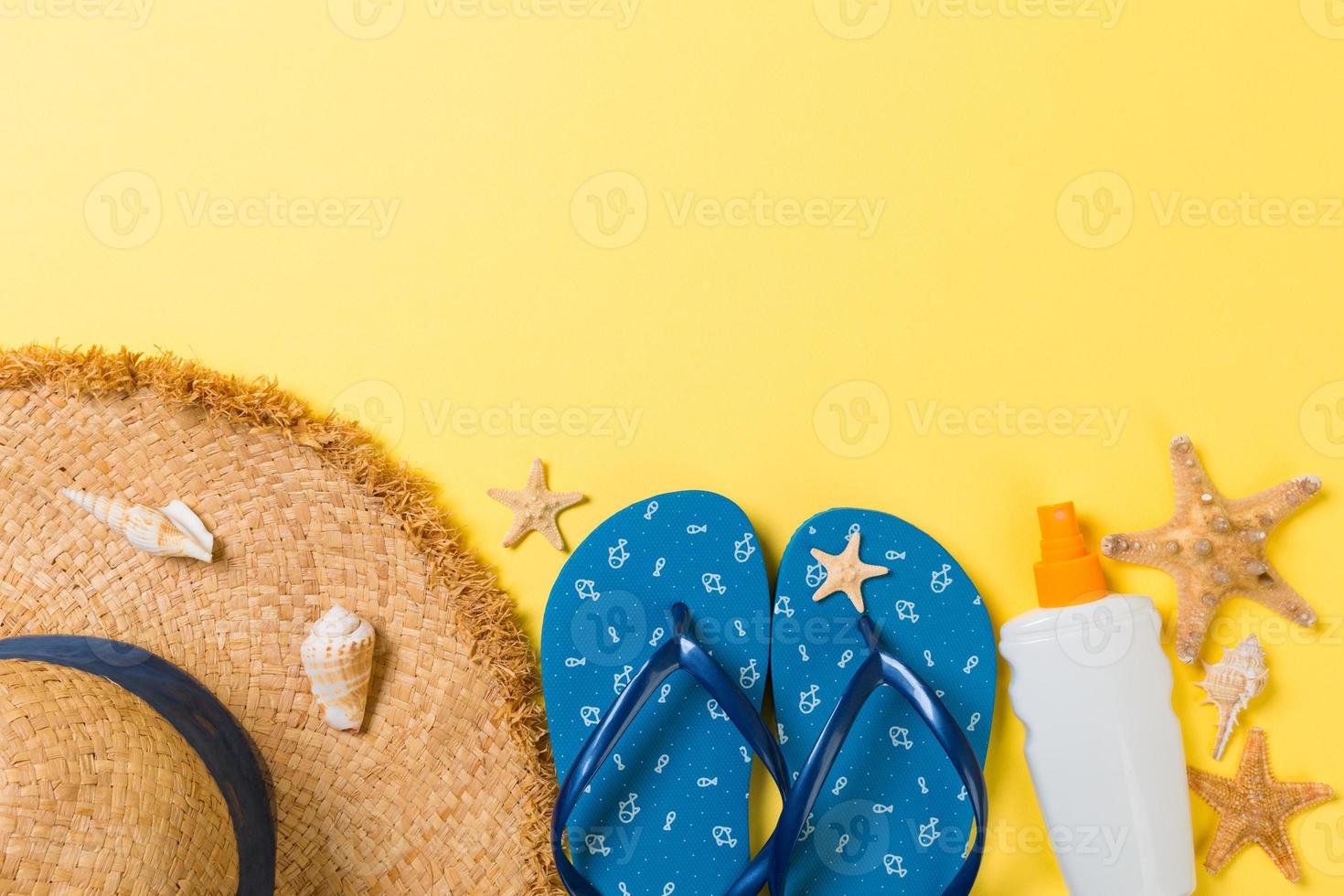 Flip flop, cannuccia cappello, stella marina, protezione solare bottiglia, corpo lozione spray su giallo sfondo superiore Visualizza . piatto posare estate spiaggia mare Accessori sfondo, vacanza concetto foto