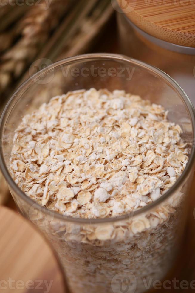 fiocchi d'avena in un barattolo con cucchiaio sul tavolo foto