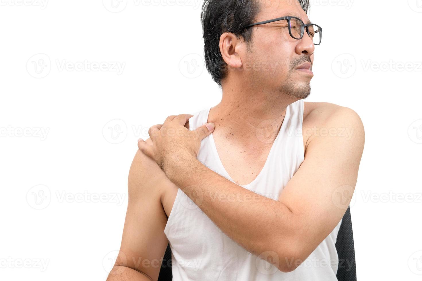 un' mezzo anziano uomo nel bianca veat sofferenza a partire dal collo e spalla dolore foto