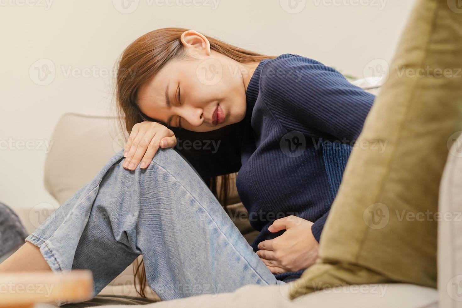 flatulenza asiatico giovane donna, ragazza mano nel stomaco dolore, soffrire a partire dal cibo avvelenamento, addominale dolore e colon problema, gastrite o diarrea. paziente gonfiarsi, addome o infiammazione, concetto. foto