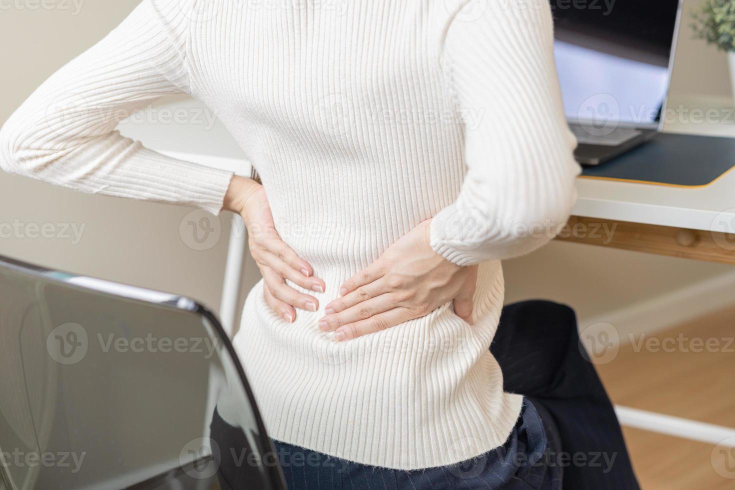 corpo muscoli rigido problema, asiatico giovane attraente donna, ragazza dolore con indietro dolore dolore a partire dal computer opera, Tenere massaggio sfregamento, male o dolorante mentre seduta su sedia a casa. assistenza sanitaria le persone. foto